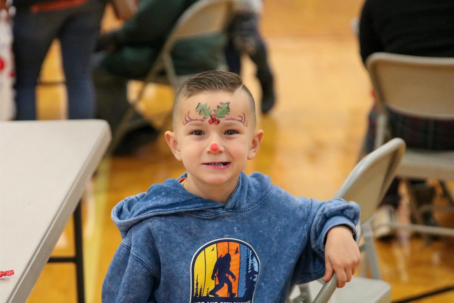  A Christmas Bureau carnival attendee is all smiles after getting his face painted during the event.