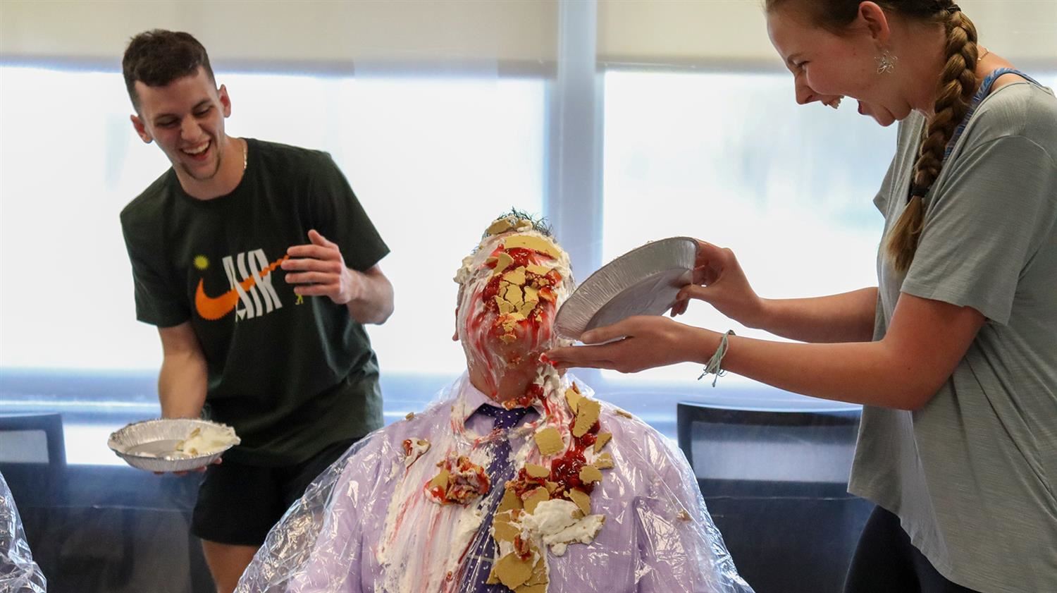HHS students Gavin Griffin and Julianna Kaufman pie Superintendent Christopher Staats.