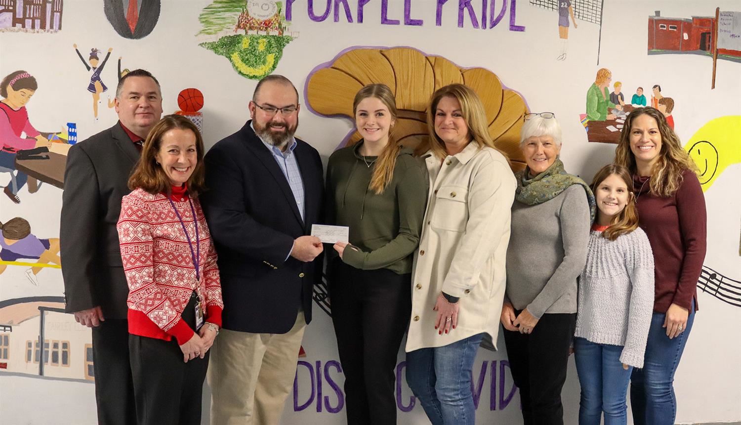 Shortslef receives a scholarship check alongside members of the Cianfarano family.