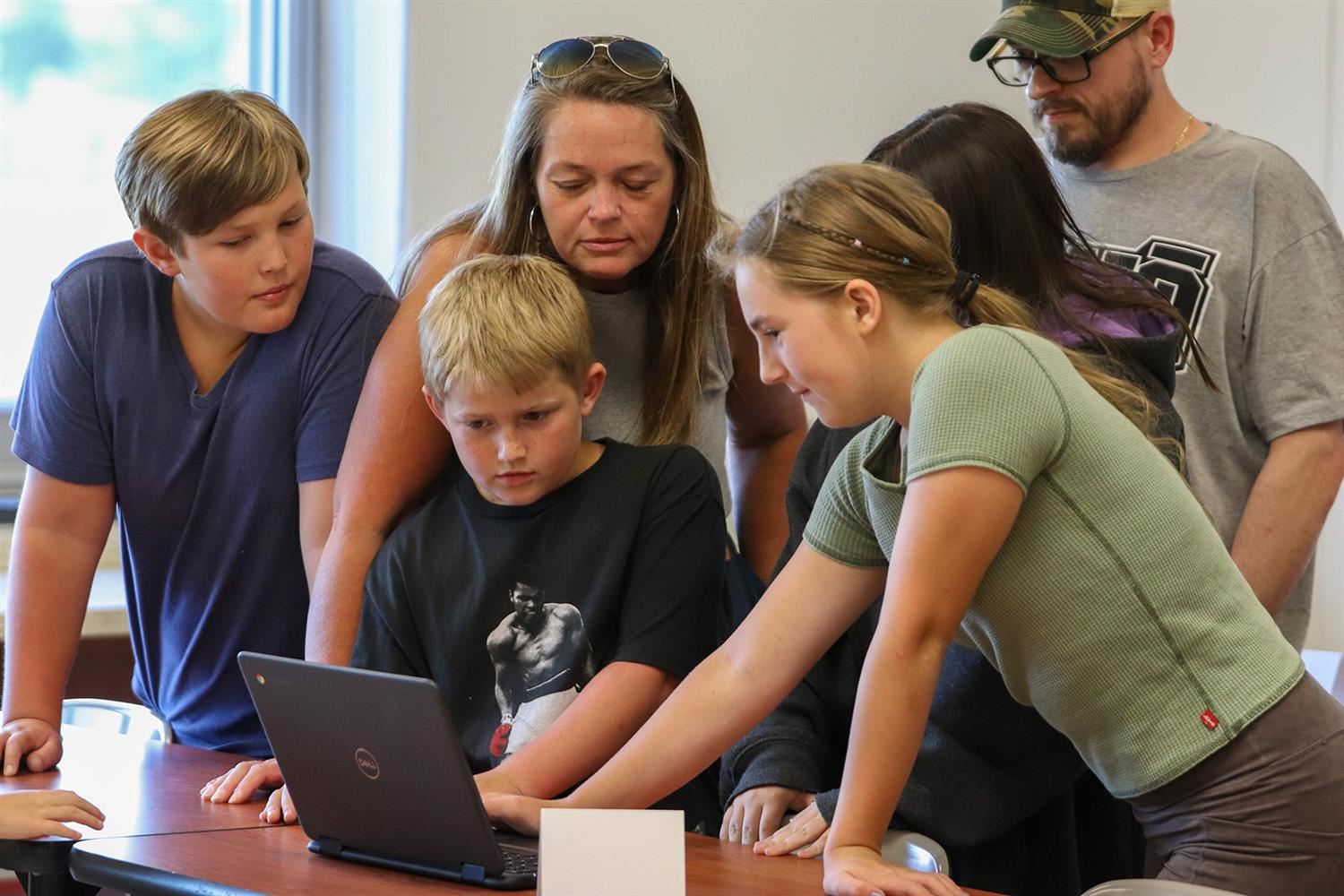  A DMK family checks out a class project in the fifth-grade wing during DMK on Display.