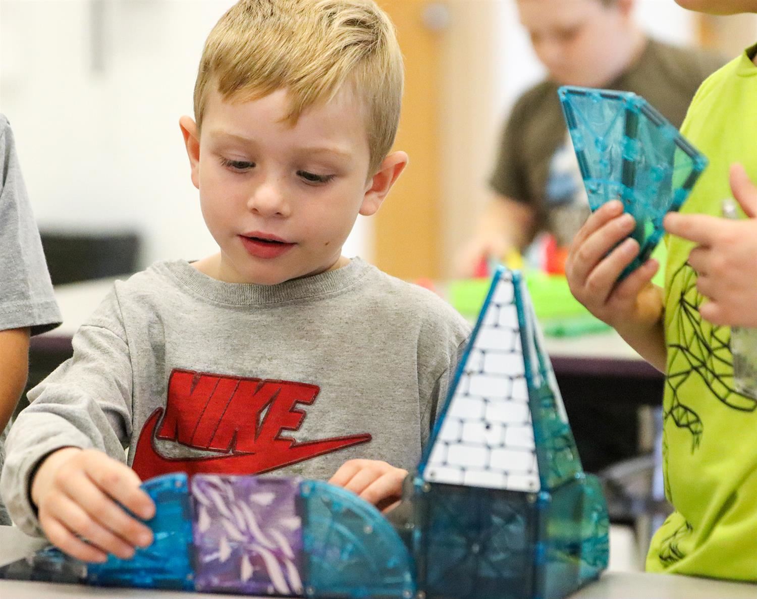  A Hannibal UPK student taps into his imagination skills while building  with Magna Tiles.